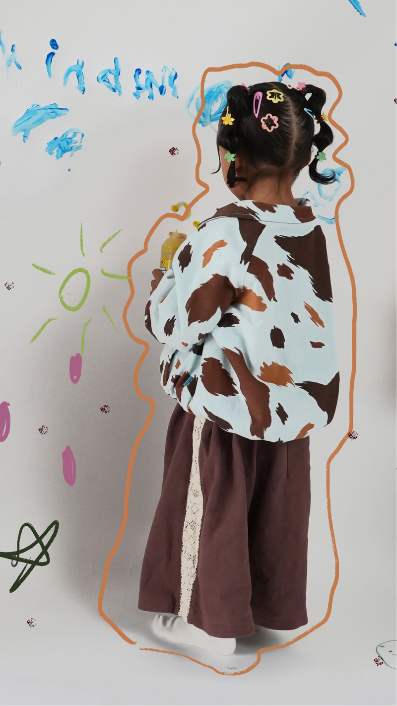 Child in oversized baggy Seffi kids winter jacket  in cow print milky way — From Y To Z kidswear NZ