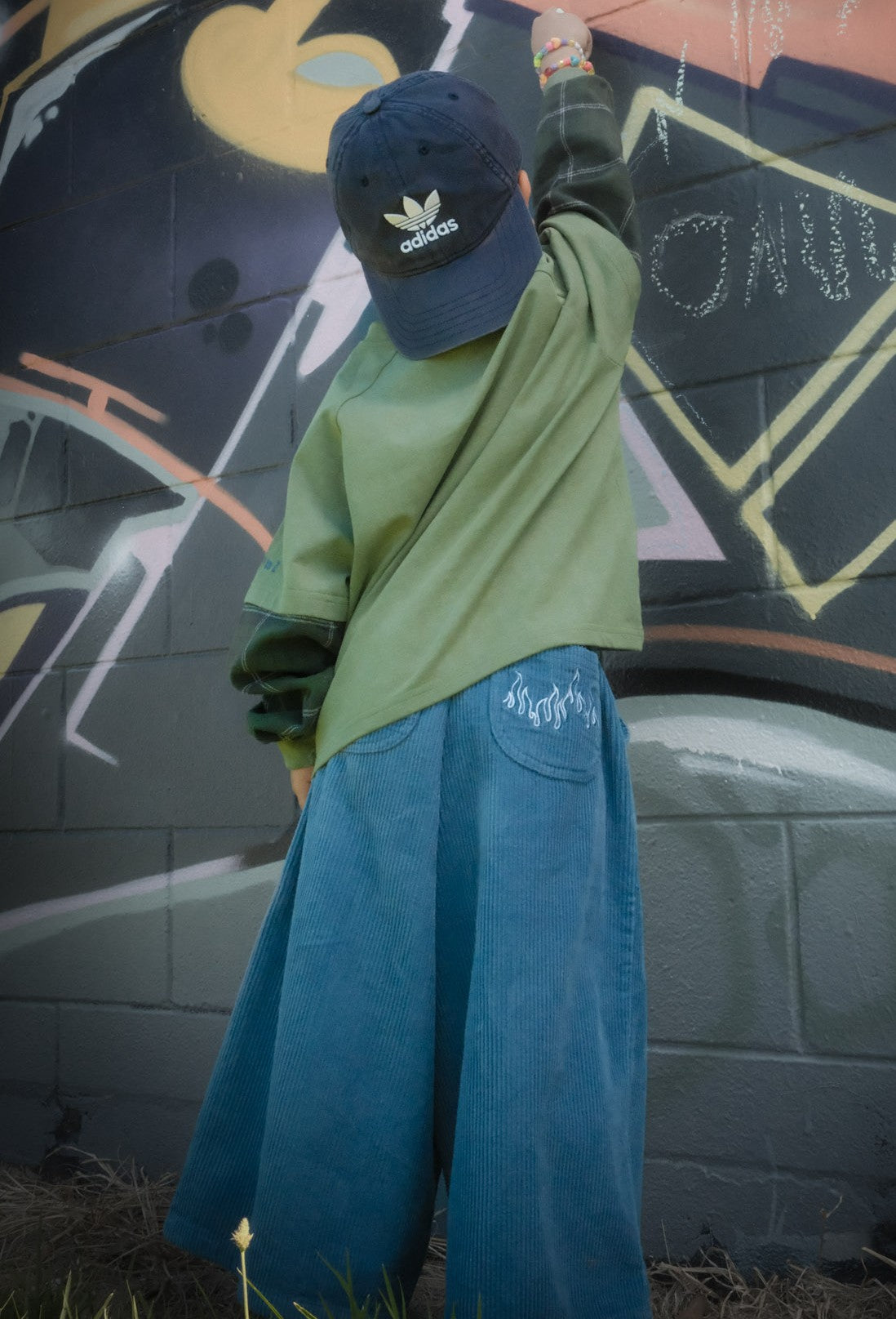 Child in wide-leg relaxed-fit blue Blaze corduroy pants with flame embroidery detail on pocket — From Y To Z kidswear NZ

