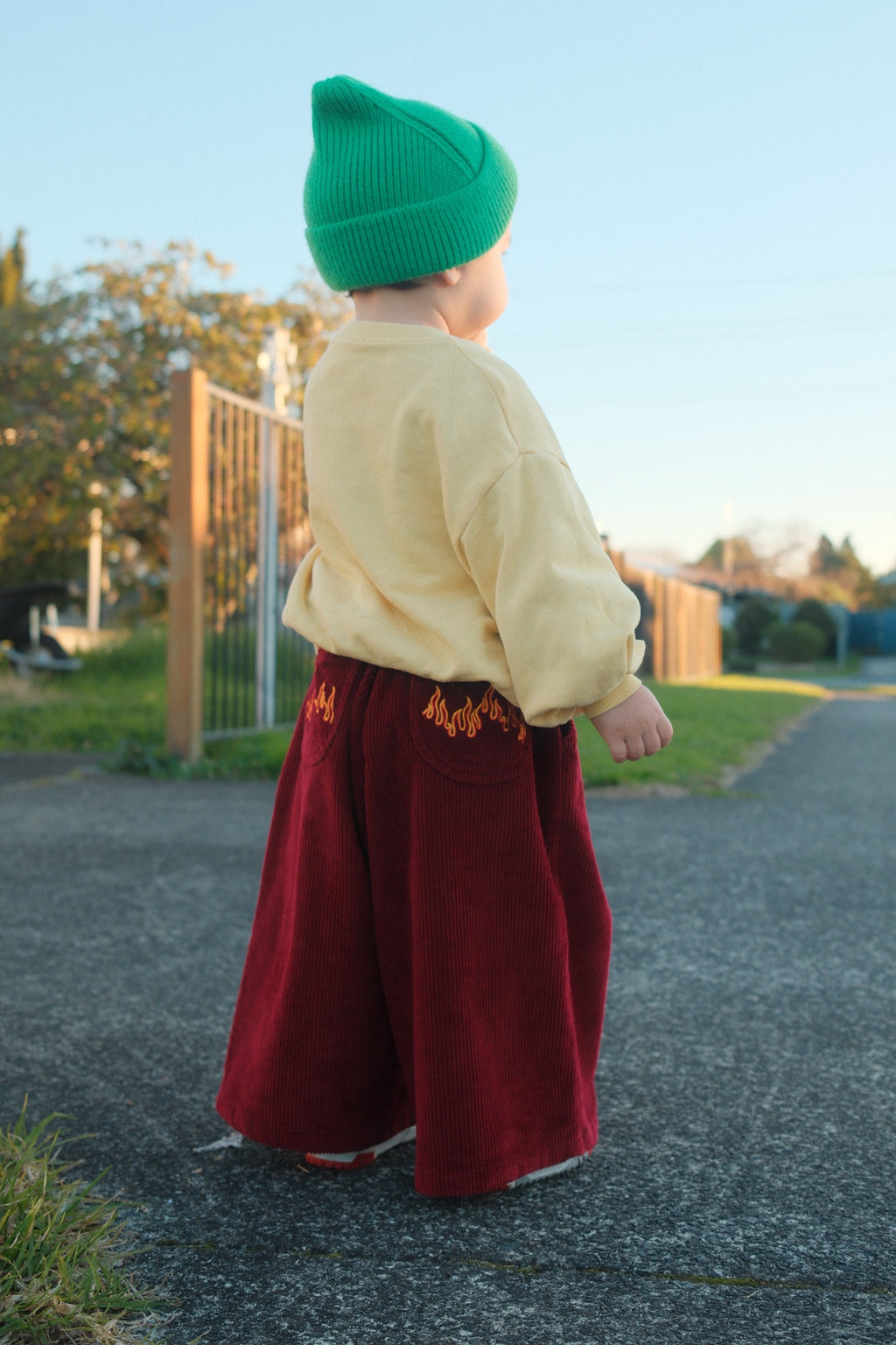 Toddler wearing Blaze cord pants in flame in a suburbian area