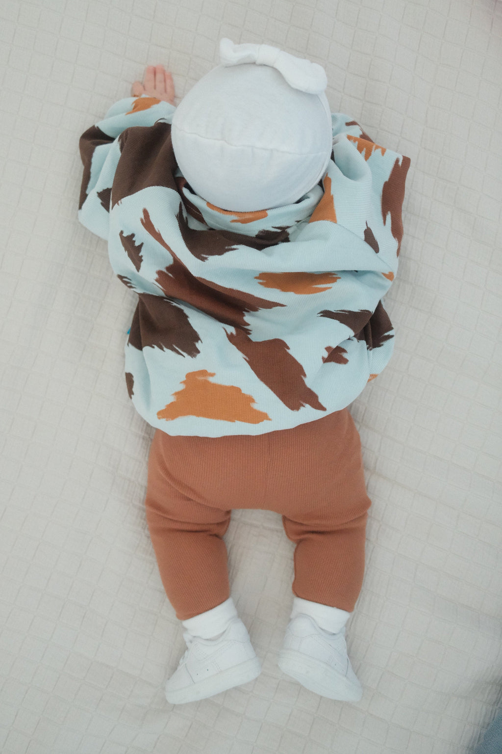 infant doing tummy time wearing seffi jacket in milkyway