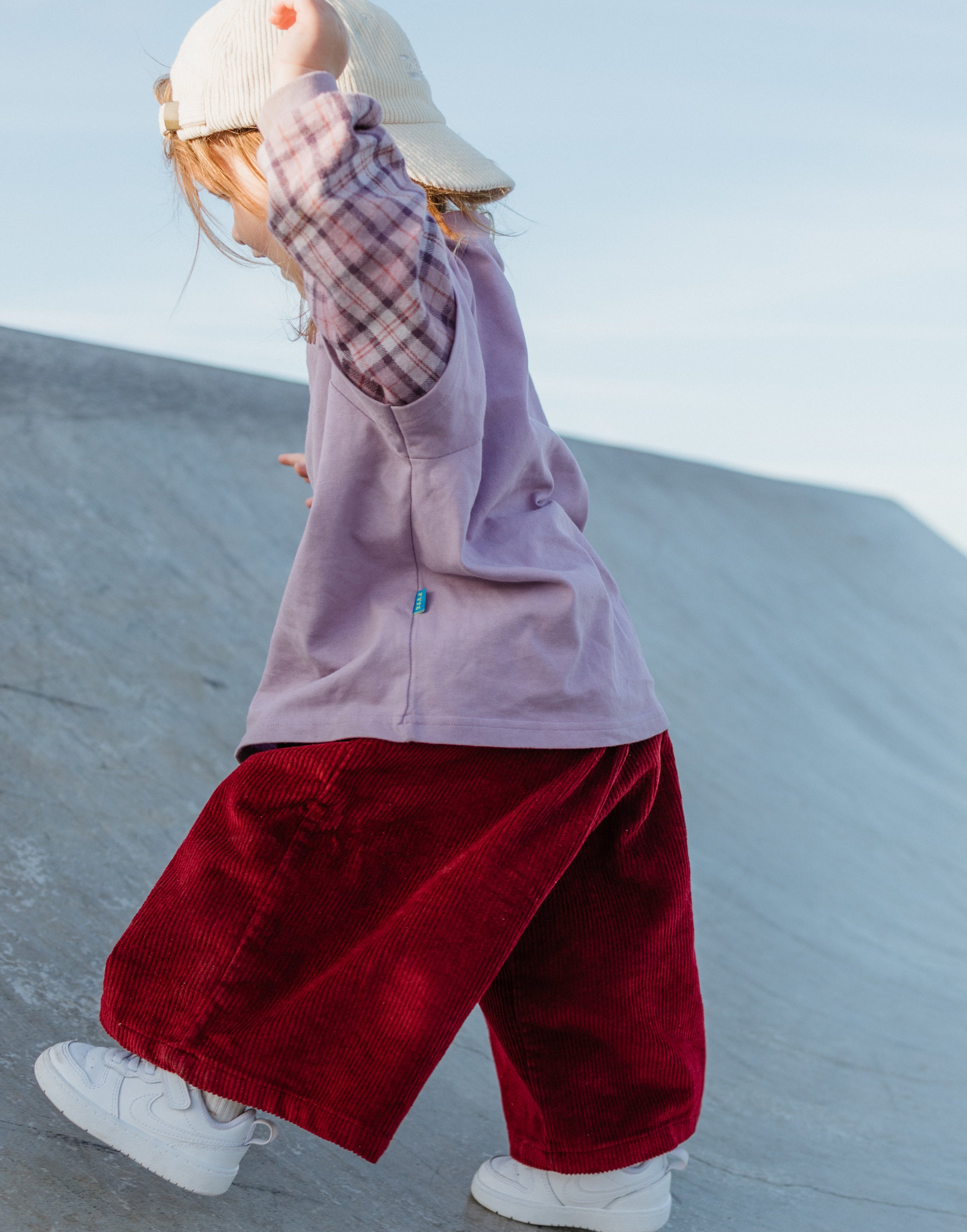 Toddler in skatepark wearing purple ollie double-sleeve 