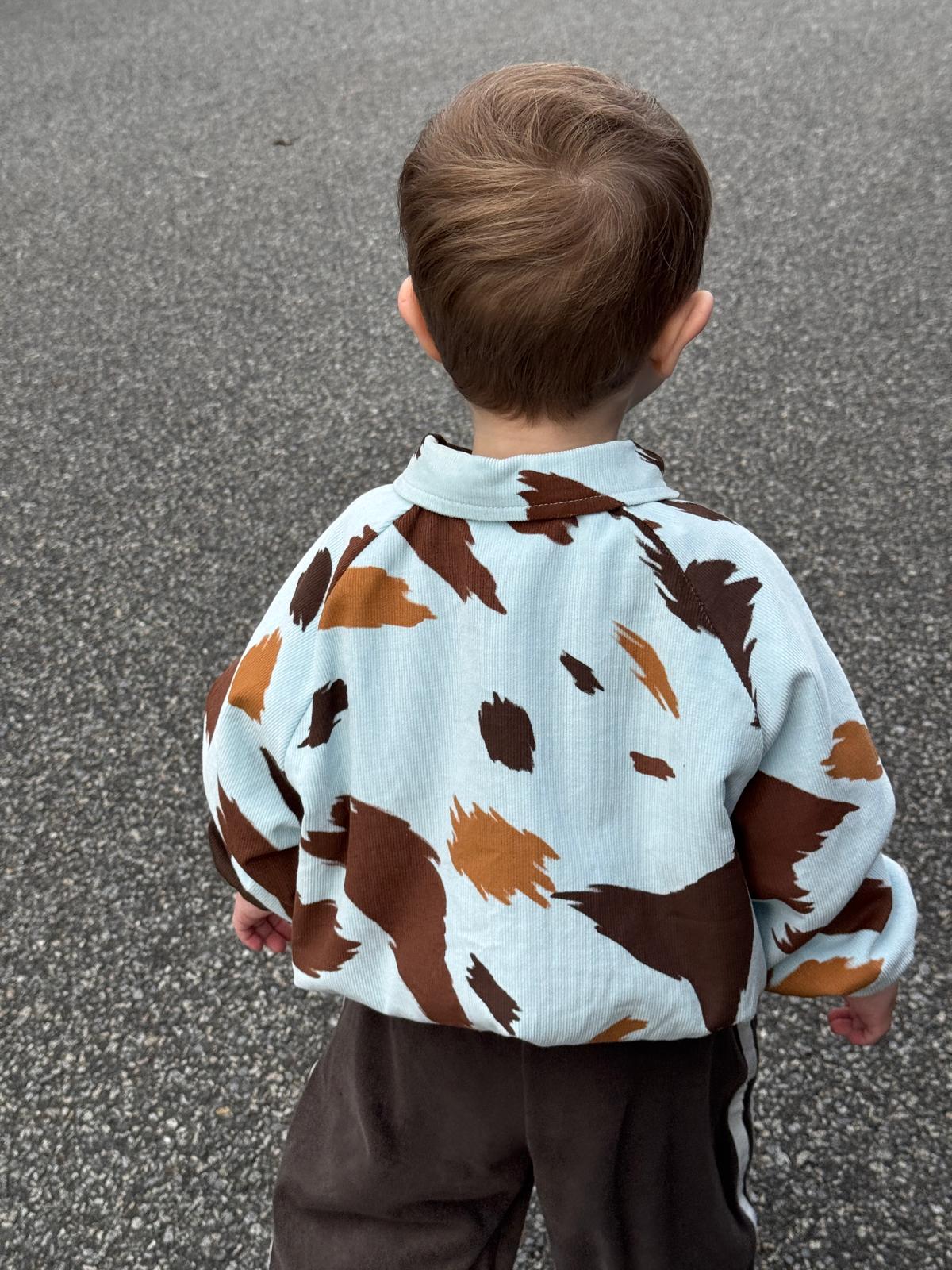 Child wearing a cow print seffi jacket in milkyway on an asphalt surface